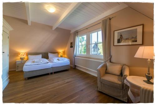 QuilitzFischerhaus in Quilitz的卧室配有床、椅子和窗户。