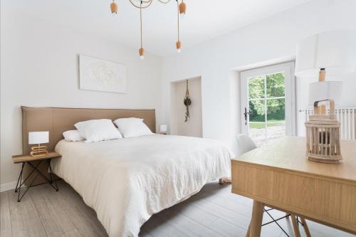 奥尔泰兹Le moulin des Sens - SPA-SAUNA的白色卧室配有一张大床和一张桌子