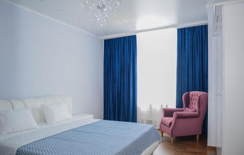 敖德萨Sea View Odessa的一间卧室配有一张床和一张粉红色的椅子