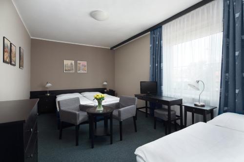 普鲁洪尼斯 潘普鲁洪尼斯图利酒店的酒店客房带两张床和一张桌子以及椅子。