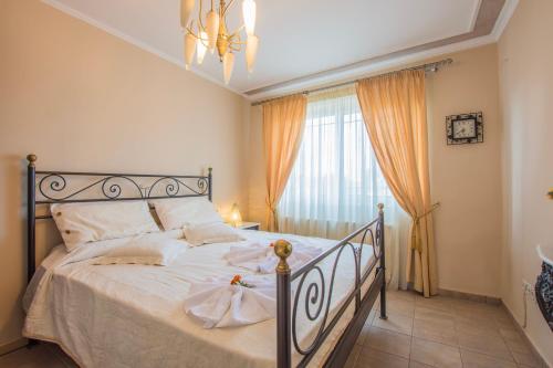 扎金索斯镇Zante View (4bedroom luxury home) Free Pickup的一间卧室配有一张带白色床单的床和一扇窗户。