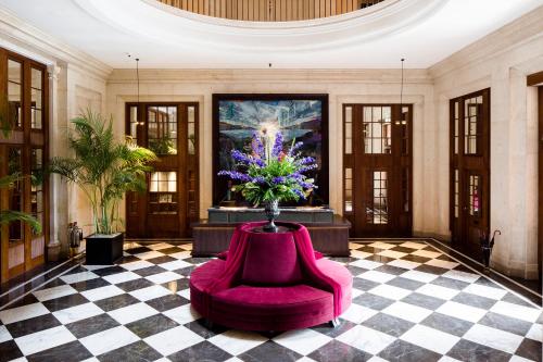 爱丁堡仕骅廷爱丁堡大酒店的大堂设有紫色椅子和花瓶