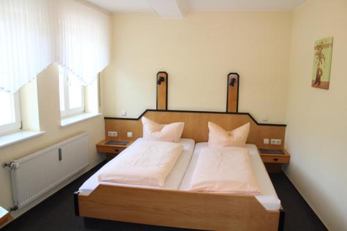 WellenPension Weber的一间卧室配有带白色床单和枕头的床。