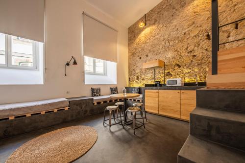 科英布拉萨派恩提亚精品酒店的厨房配有桌椅和石墙