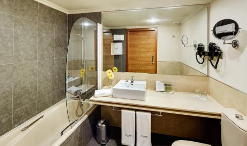 巴达霍斯苏尔巴然斯考特大酒店的一间带水槽和浴缸的浴室