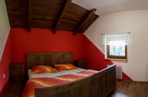 StrmicaHoliday House Vodice na Lazu的一间卧室设有一张带红色墙壁的大床