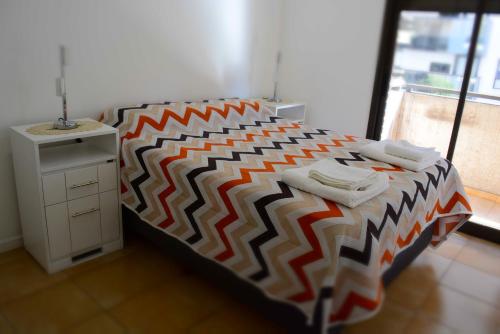 科尔多瓦Santorini 1的一间卧室配有一张带彩色床罩的床