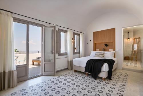皮尔戈斯White & Co. La Torre Suites的一间卧室设有床和滑动玻璃门