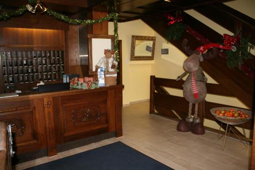 巴德哥依斯恩巨龙酒店的站在一个拥有圣诞装饰的房间的柜台上的人