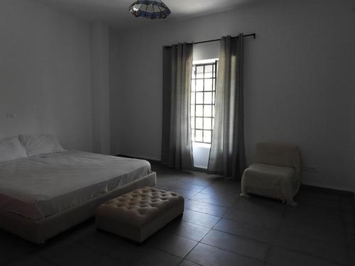 哈马马特Appartement quartier Dar Sebastian, Hammamet的卧室配有床、椅子和窗户。