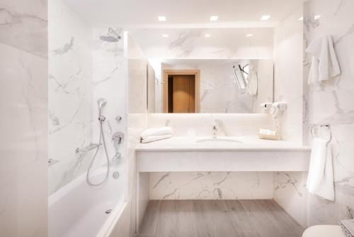 马斯蒂查里海滩地平线度假酒店的白色的浴室设有水槽和淋浴。
