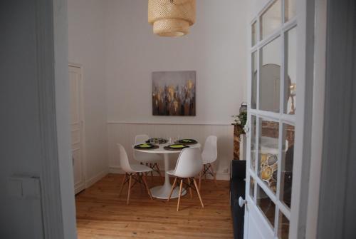 图卢兹L'authentique - Coeur de ville的一间带桌子和白色椅子的用餐室