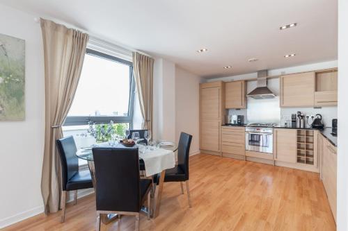 爱丁堡Stylish Garden View Apartment的厨房以及带桌椅的用餐室。