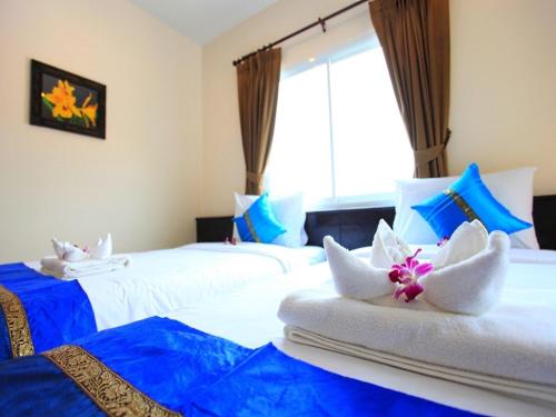 芭东海滩88酒店的蓝色和白色的客房内的两张床