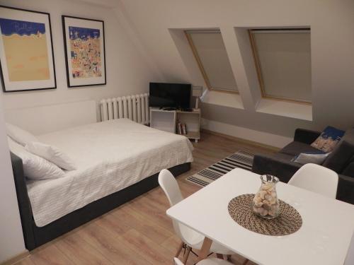 科沃布热格Apartamenty Starówka的一间卧室配有一张床、一张桌子和一张沙发