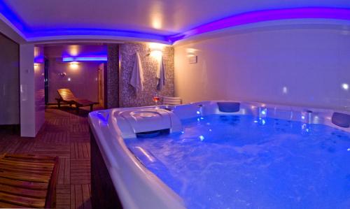 普拉维拉达马客房公寓的浴室设有大浴缸,拥有紫色照明