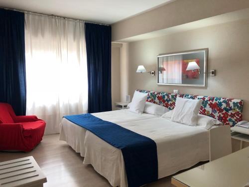 阿尔内多维尔雷酒店的酒店客房设有一张大床和一张红色椅子。