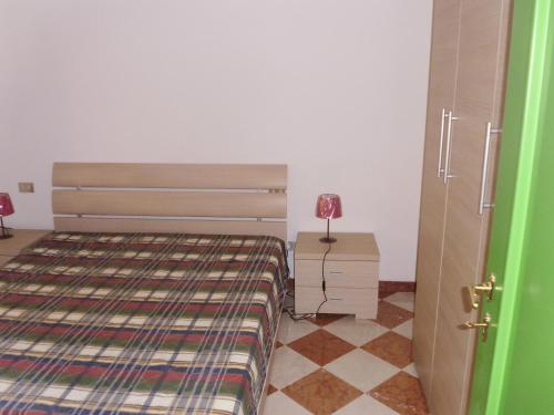 卡韦达戈Residenza Graziella的一间卧室配有一张床和一张带台灯的桌子