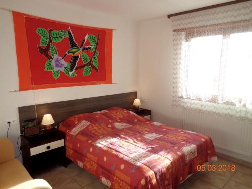 阿梅尔斯克维丁香镇旅馆的卧室配有一张床,墙上挂有绘画作品
