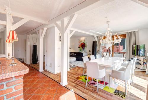 塞巴特阿尔贝克Haus Kieferngrund的用餐室以及带白色桌椅的起居室。