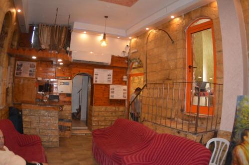 耶路撒冷棕榈旅馆的一间带红色椅子的客厅和一间厨房