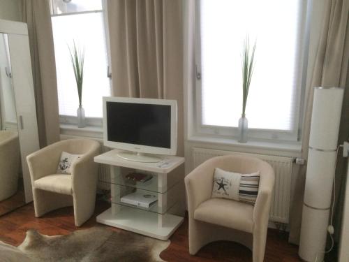 布伦瑞克feelgood Apartments - Apartment Chic的客厅配有2把椅子和电脑显示器
