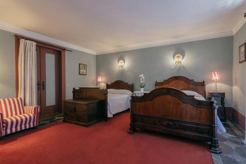 吉马良斯Casa Dos Pombais的一间卧室配有两张床,铺有红地毯