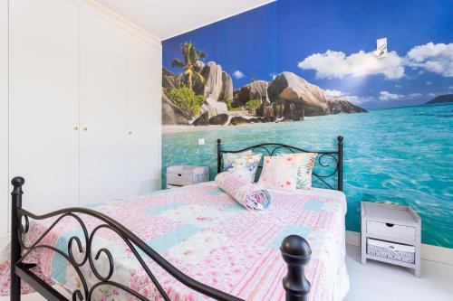 波尔蒂芒Tropical Beach Apartment Litoralmar的一间卧室配有一张带海洋绘画的床