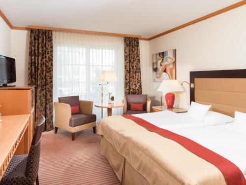 奥斯赛拜-屈隆斯博恩奥斯特西库伦伯恩旅游魅力酒店的酒店客房设有一张大床和一台电视。