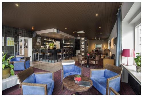 奥斯坦德特尔斯特里普酒店的一间设有蓝色椅子和桌子的餐厅和一间酒吧