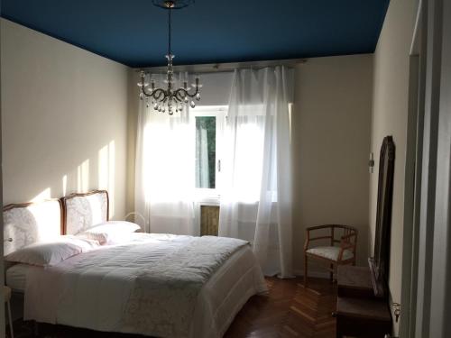 奥斯塔Beaucoeur的一间卧室配有一张床、一个吊灯和一扇窗户