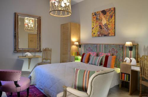 索米尔圣皮埃尔酒店的一间卧室配有一张床、两把椅子和镜子