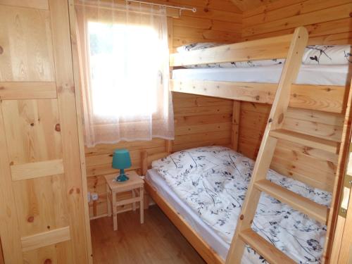 米耶伦科Anielsko domki nad morzem的一间卧室设有两张双层床和梯子