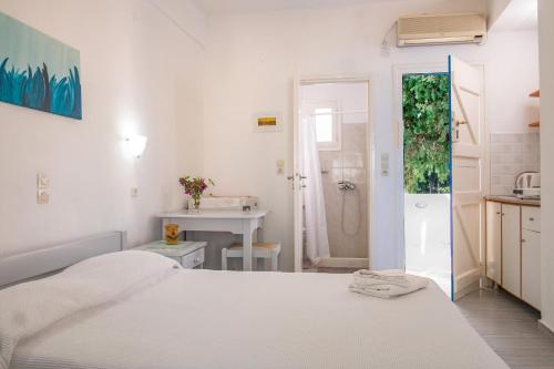 德里奥斯尼克勒塔一室公寓酒店的一间白色卧室,配有床和一间浴室