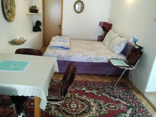 扎布利亚克Apartments Obradović Milan的卧室配有一张床和一张桌子及椅子