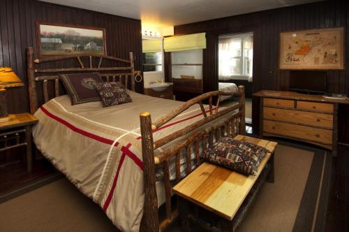 库珀斯敦Cobblescote on the Lake的一间卧室配有木床和木板凳