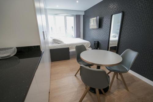 比亚里茨Bellevue 766 Biarritz的小房间设有桌椅和一张床
