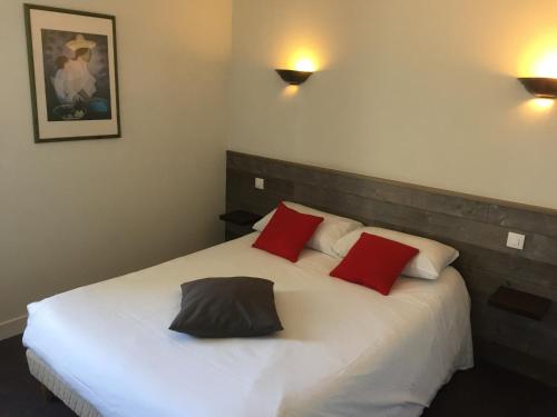 坎佩尔TGV酒店的卧室配有带红色枕头的大型白色床