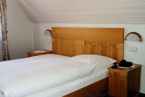 阿尔道夫瓦尔德内尔宾馆的一间卧室配有一张大床和木制床头板