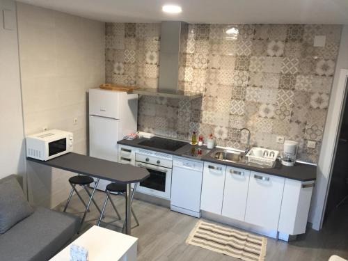 哈兰迪雅·德·拉·维尔Apartamento San Miguel N.3的厨房配有白色橱柜、水槽和桌子