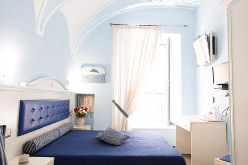 维耶斯泰瑞雷帕拉勒罗41号住宿加早餐旅馆的一间卧室设有蓝色的床和窗户。