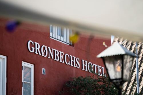 阿灵厄Grønbechs Hotel的一座红色的建筑,上面有看书的标志