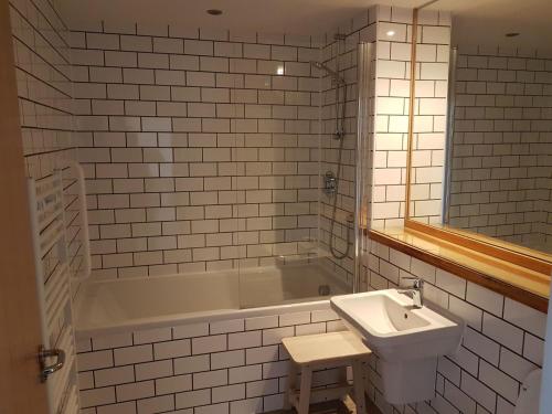 斯托诺韦Stornoway Lido flats的浴室配有盥洗盆和浴缸。