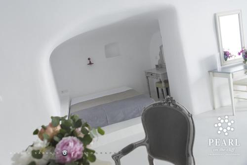 易莫洛林Pearl on the Cliff Hotel & Suites by Pearl Hotel Collection的一间卧室配有一张床、一把椅子和花瓶