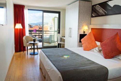 戛纳伊甸园酒店&Spa的酒店客房设有一张床和一个阳台。