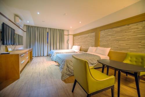 仁川市Incheon Airport Hotel Zeumes的配有一张床、一张桌子和一张桌子的酒店客房