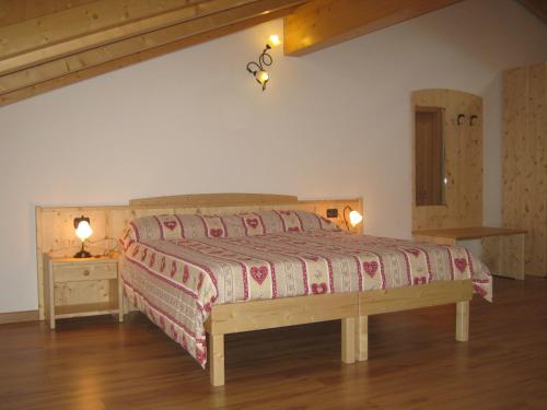 布雷斯皮萨尼农庄酒店的一间卧室配有一张大床和木制床头板