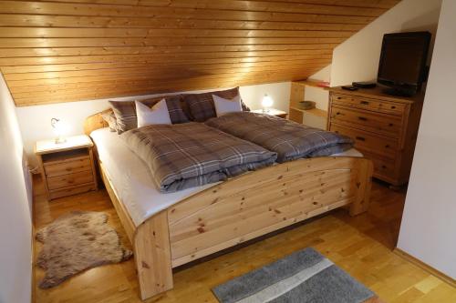 RiegseeHaus Riegseeblick的一间卧室设有一张带木制天花板的大床