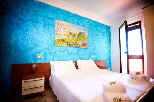 莫尔恰诺迪莱乌卡B&B NiloSira的一间卧室设有两张床和蓝色的墙壁