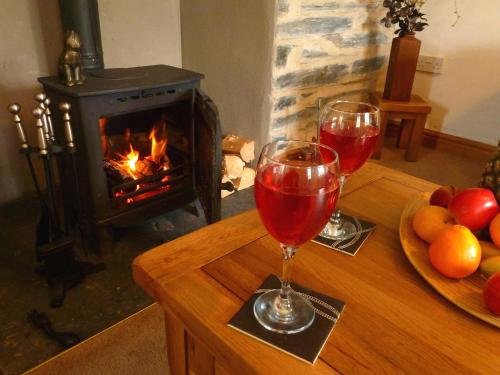 多尔威泽兰Dolmurgoch Snowdonia Cottage的壁炉桌上的两杯红葡萄酒